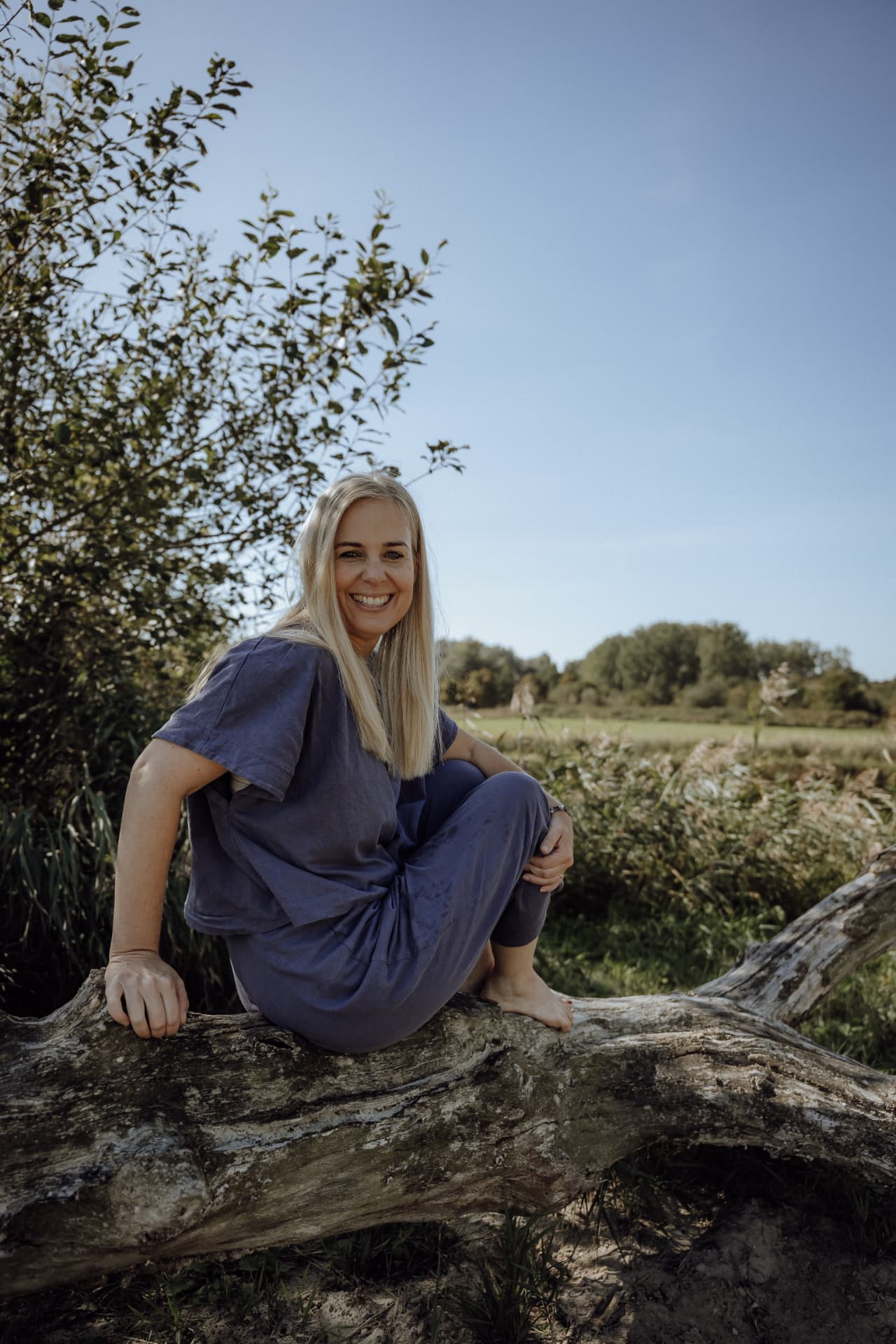 Berber van der Meer zittend op een boomstam in de natuur